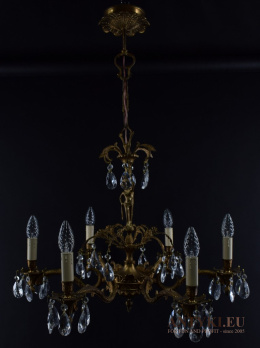 Antyczny żyrandol mosiężny z kryształami w pałacowym stylu.