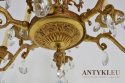 Duży antyczny żyrandol mosiężny z kryształami w barokowym stylu.