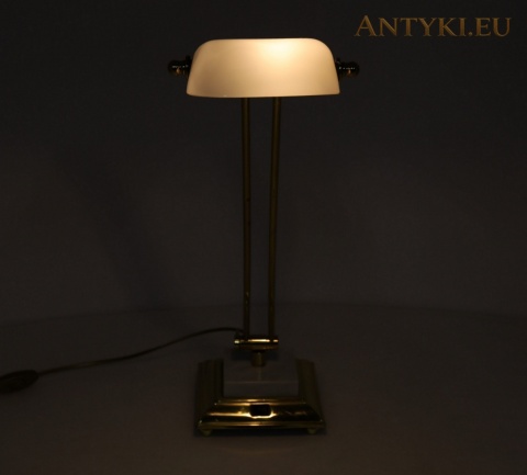 włączona lampa bankierska z ramieniem ustawionym pionowo, widok z przodu