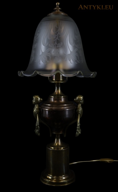 antyczna lampa stołowa z ozdobnym kloszem na czarnym tle