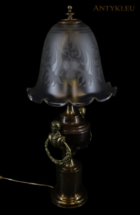 lampa z mosiężnym korpusem i bocznym uchwytem na ciemnym tle