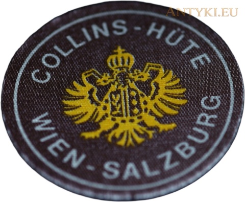 Okrągła etykieta Collins-Hüte Wien-Salzburg na jasnym tle