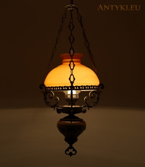 zapalona lampa wisząca z miodowym kloszem dającym ciepłe światło