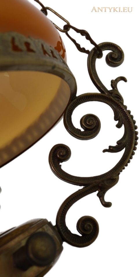 spiralnie zakończone mosiężne ramię przy szklanym kloszu lampy