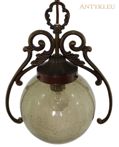 lampa z oliwkowo-dymną kulą i symetrycznymi mosiężnymi wolutami