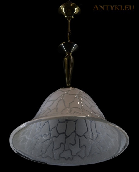 lampa z mosiężnym zawieszeniem i grubym szklanym kloszem na czarnym tle