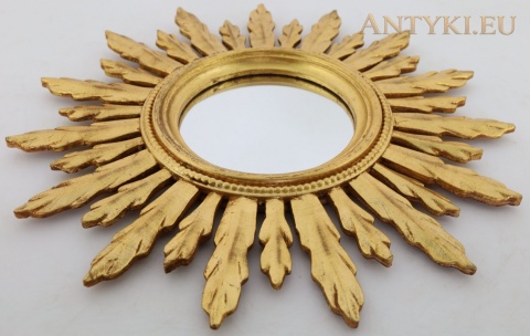 lustro sunburst leżące pod kątem z widoczną rzeźbioną ramą