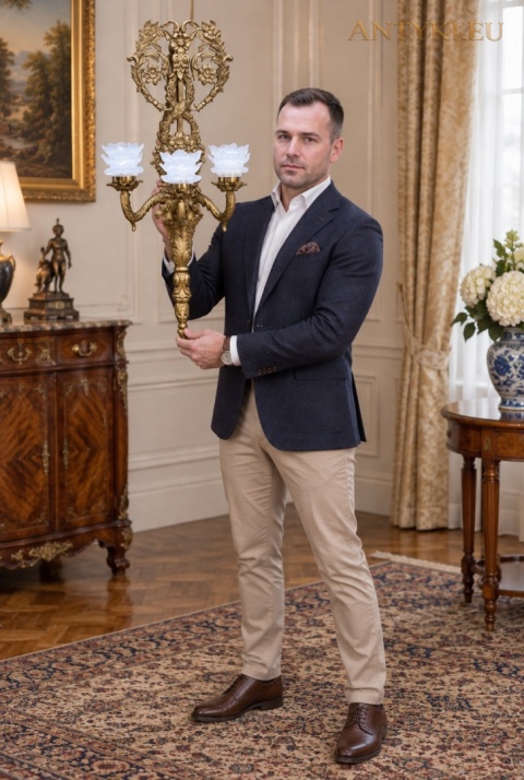 okazały kinkiet prezentowany przez mężczyznę w klasycznym wnętrzu